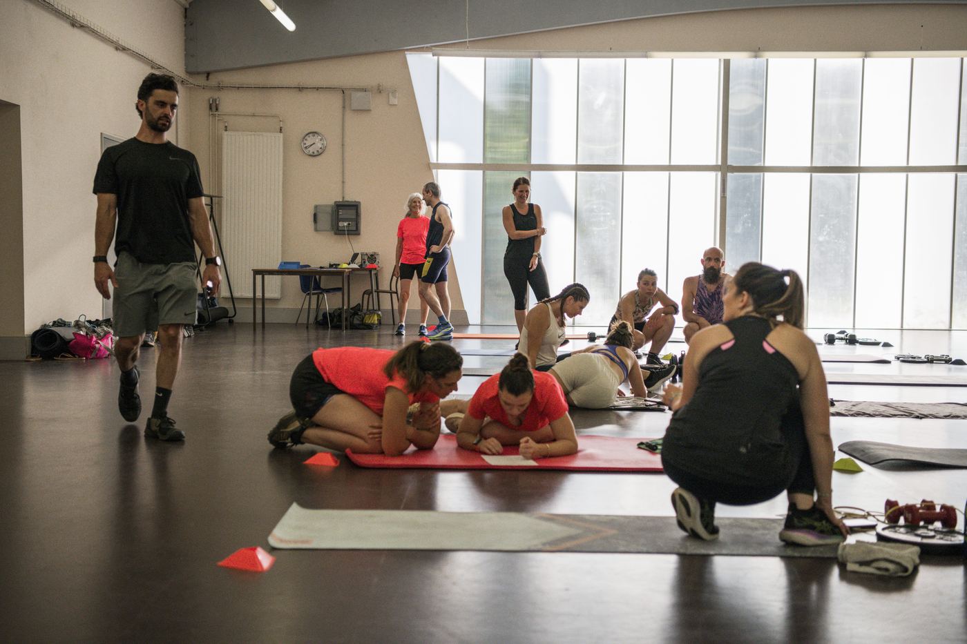 Le préparateur observe le groupe pendant un exercice de gainage sur tapis